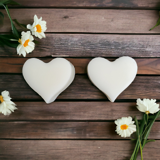 Two white elegant heart soy wax melts with wooden background and white flowers