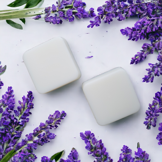 Two white square soy wax melts with lavender flowers in the background