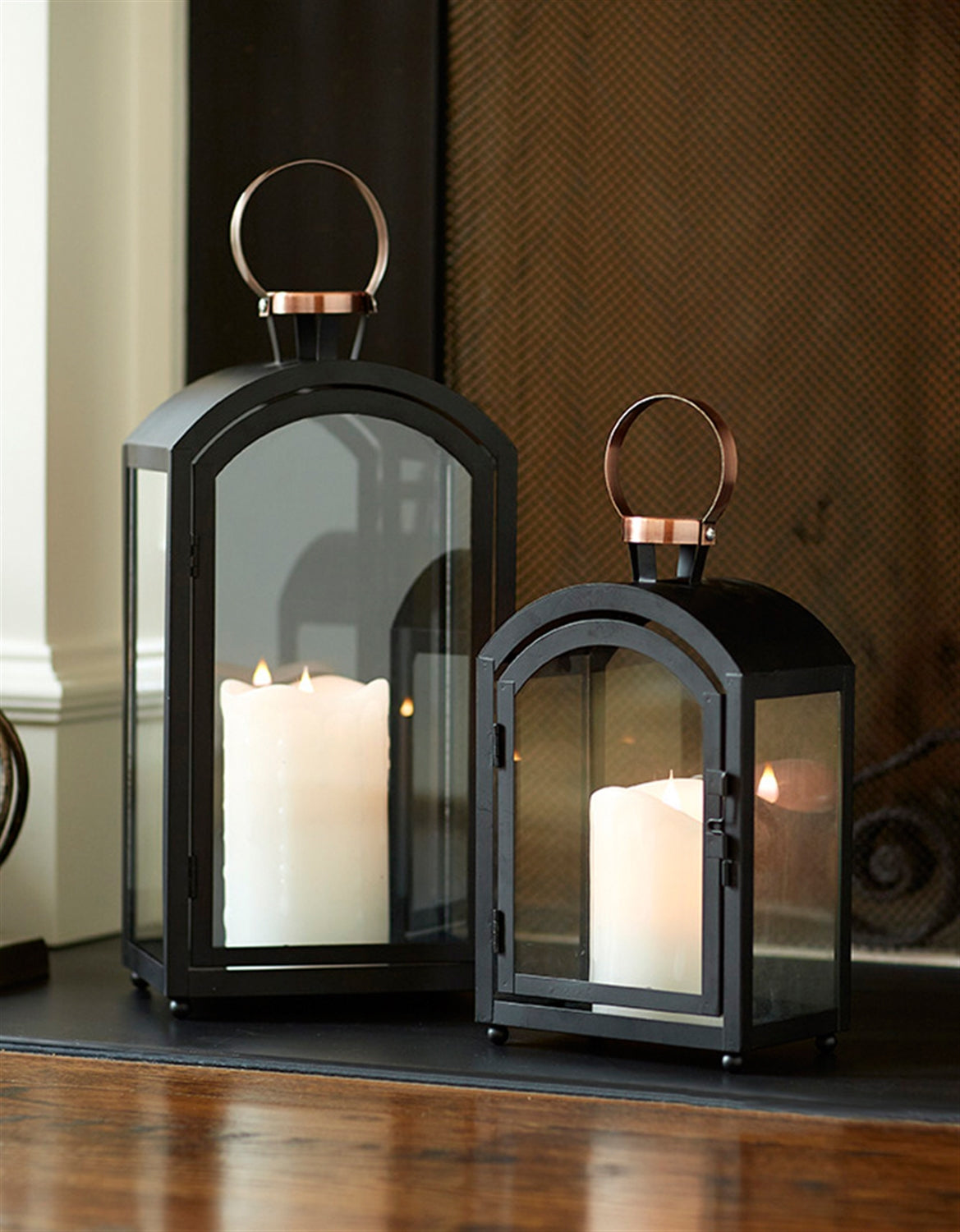 Modern black and copper metal glass lantern with white candles. Candles not included.  