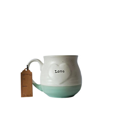 Speckled cream and mint green " Love" coffee mug.  " Love" is creatively etched on the heart on both sides the mug.